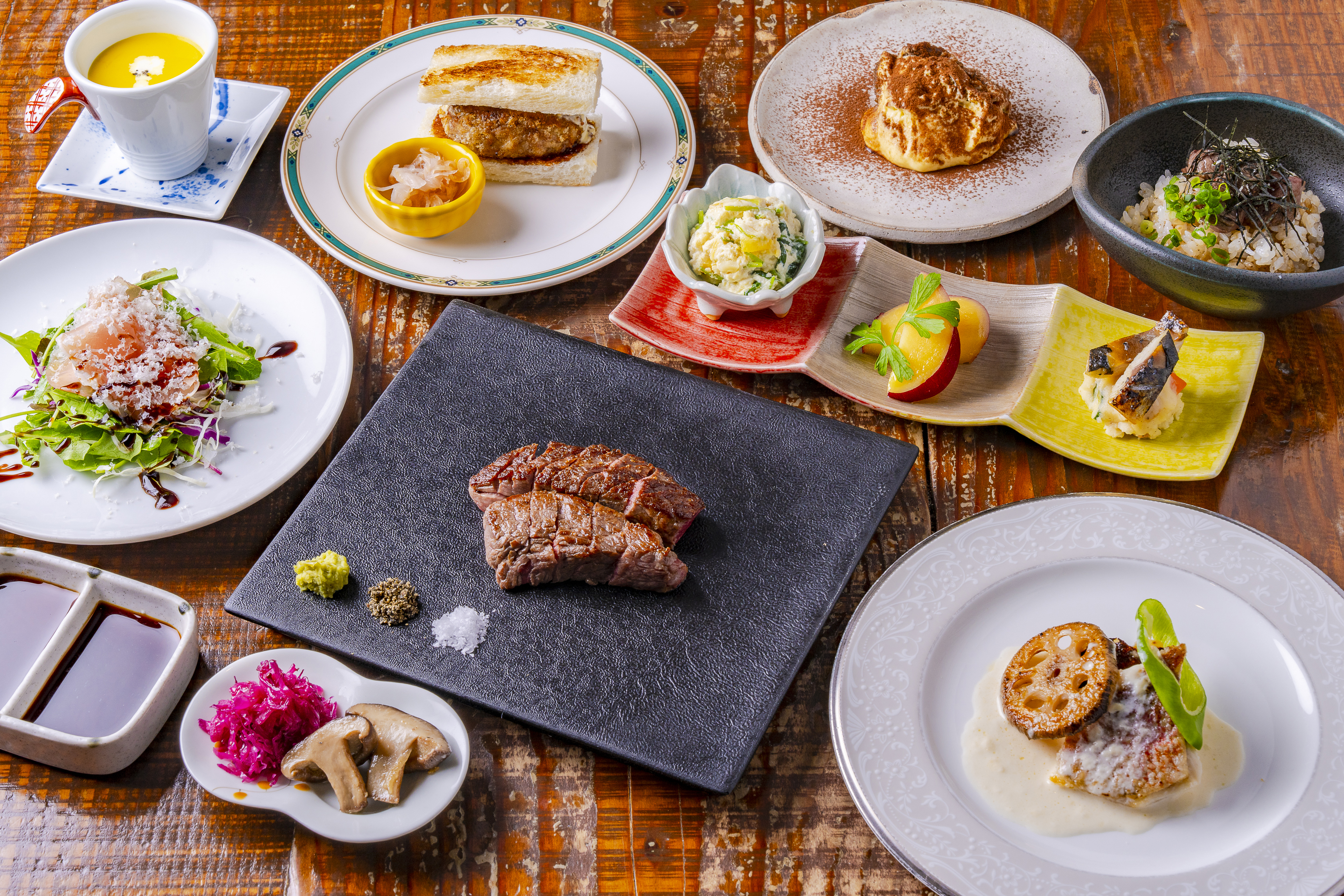 ステーキや前菜を盛り付けたGRILL末松のディナーコース